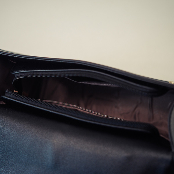 Μικρή όμορφη τσάντα με ιμάντα ώμου πάνω από τον ώμο του