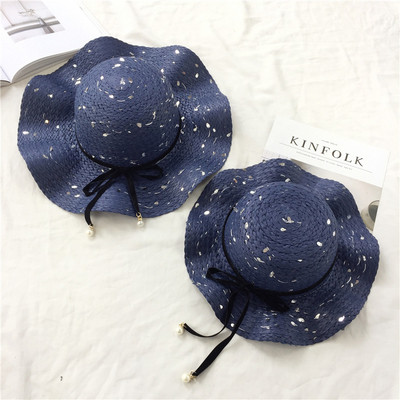 Κυρίες ψάθινο καπέλο στην παραλία με όμορφη κορδέλα