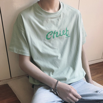 Σύγχρονη αρσενικό ευρύ-shirt με κοντά μανίκια και ένα στήθος επιγραφή