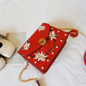 Μια μεγάλη τσάντα με χάντρες και κεντήματα των λουλουδιών με μακριά λαβή ώμου