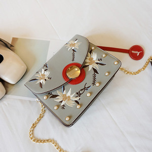 Μια μεγάλη τσάντα με χάντρες και κεντήματα των λουλουδιών με μακριά λαβή ώμου