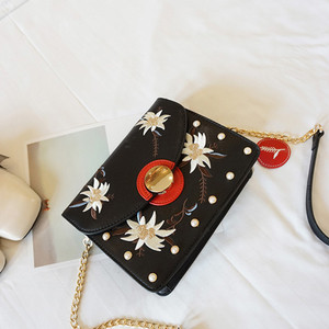 Μια μεγάλη τσάντα με χάντρες και κεντήματα των λουλουδιών με μακριά λαβή ώμου