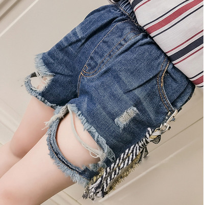 Много модерни къси разкъсани дънкови панталони за момиче