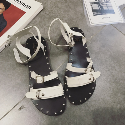 Οι γυναίκες κομψά σανδάλια με λουριά και μεταλλικά στοιχεία σε λευκό, μαύρο και καφέ