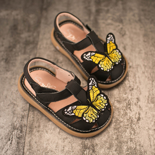 Όμορφη παιδικά σανδάλια για κορίτσια σε μαύρο και ασημί, διακοσμημένο με πεταλούδες