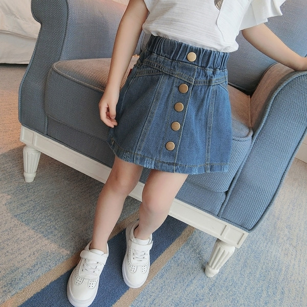 Σημερινό μοντέλο φούστα για τα κορίτσια με υψηλή μέση και μεγάλα κουμπιά κάτω από το μέτωπο