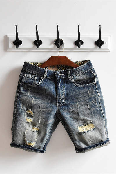 σύντομο τζιν Μοναδικό των ανδρών σε ένα σκούρο χρώμα και ψιλοκομμένο