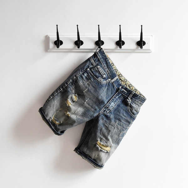 σύντομο τζιν Μοναδικό των ανδρών σε ένα σκούρο χρώμα και ψιλοκομμένο