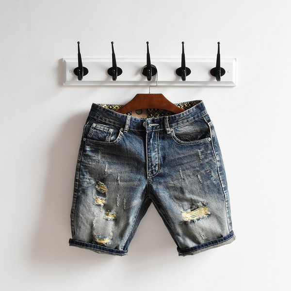 σύντομο τζιν Μοναδικό των ανδρών σε ένα σκούρο χρώμα και ψιλοκομμένο