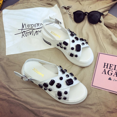 Οι γυναίκες σανδάλια με σταυρωμένα τα λουριά και πέτρες και βολική πλατφόρμα