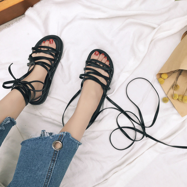 Όμορφη σανδάλια για τις κυρίες με μακριά kozhein δεσμούς σε μαύρο χρώμα