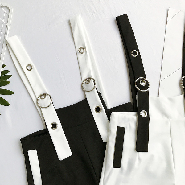 Κομψό κυρίες jumpsuit σε μαύρο και λευκό με μεταλλικούς κρίκους