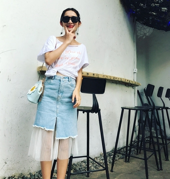 Μια ενδιαφέρουσα ασύμμετρη φούστα τζιν με ένα λεπτό γόνατο ξυριστική μηχανή