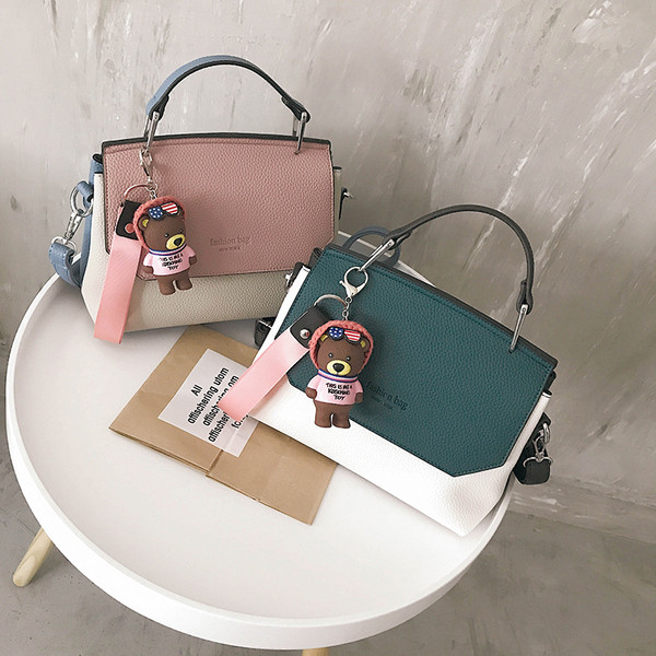 Γυναικεία τσάντα με δύο τύπους χειρολαβών και μια διακόσμηση αρκούδας