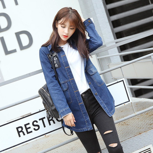 Ένα μακρύ γυναικείο μπουφάν τζην  με μπλε εγχάρακτη επιγραφή