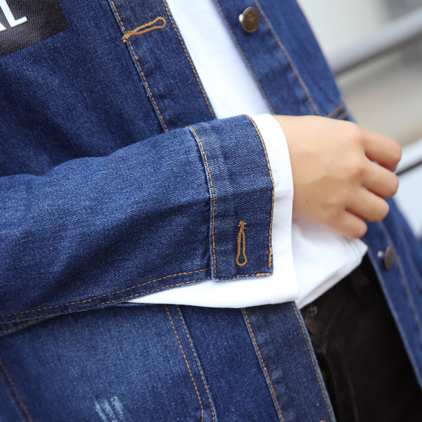 Ένα μακρύ γυναικείο μπουφάν τζην  με μπλε εγχάρακτη επιγραφή