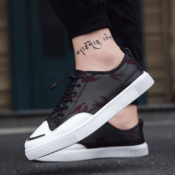 Ανδρικά πάνινα παπούτσια σε λευκό και μαύρο χρώμα που καλύπτονται με ένα πλέγμα κατάλληλα για καθημερινή ζωή