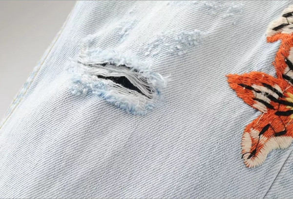 Πολύ σύγχρονα γυναικεία τζιν με όμορφα κεντήματα μπλε και  ανοιχτό μπλε με ξεθωριασμένα γόνατα