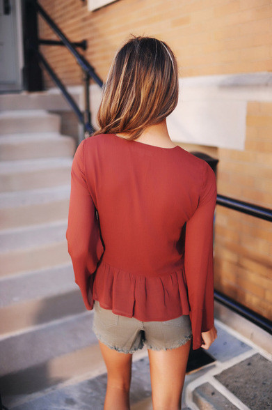 Κομψή γυναικεία  μπλούζα σε ένα ευρύ μοτίβο με πέπλα και δεσμούς