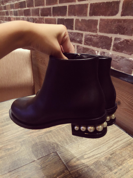 Κομψές γυναικείες μπότες σε μαύρο χρώμα με διακόσμηση και τακούνι