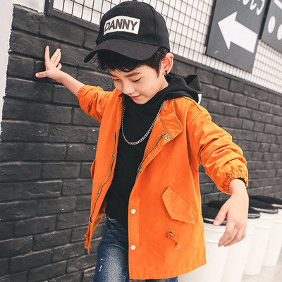 Μακρύ φθινοπωρινό μπουφάν για αγόρια με μια επιγραφή στην πλάτη σε μαύρο και πορτοκαλί χρώμα