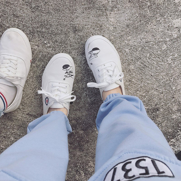 Απλά γυναικεία αθλητικά παπούτσια σε λευκό και μαύρο χρώμα με μια εικόνα