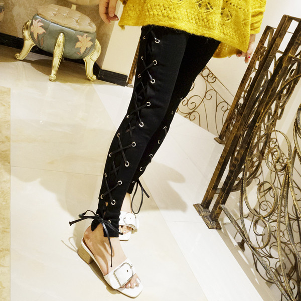 Стилни дамски панталони в черен цвят с кръстосани връзки по дължината