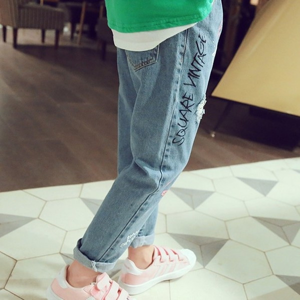 Παιδικά τζιν για κορίτσια με πολύχρωμες εφαρμογές και επιγραφές