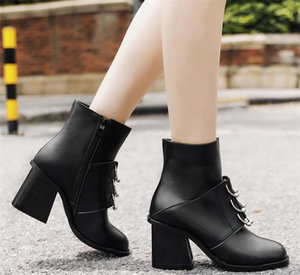 Κομψές γυναικείες μπότες σε μαύρο χρώμα με μεταλλικά σκουλαρίκια