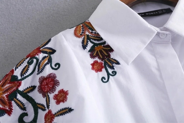 Όμορφο γυναικείο πουκάμισο με λουλούδια σε λευκό χρώμα