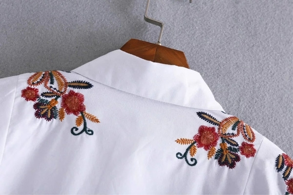 Όμορφο γυναικείο πουκάμισο με λουλούδια σε λευκό χρώμα