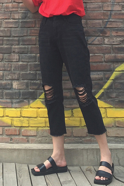 Κομψά γυναικεία τζιν σε μαύρο χρώμα και σκισμένα