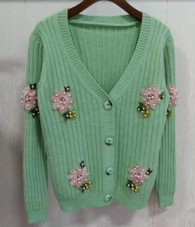 Σύγχρονη γυναικεία ζακέτα με ενδιαφέρουσες καρφίτσες, κουμπιά και ντεκολτέ σε σχήμα V