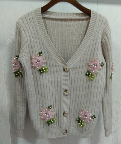 Σύγχρονη γυναικεία ζακέτα με ενδιαφέρουσες καρφίτσες, κουμπιά και ντεκολτέ σε σχήμα V