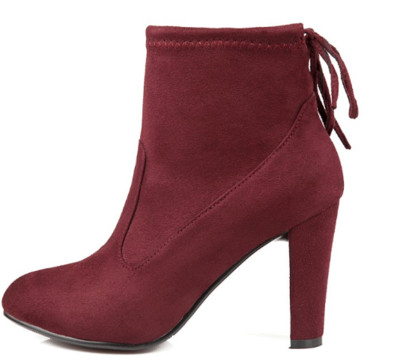 Γυναικείες μπότες με ψηλά τακούνια και ενδιαφέρουσες κορδέλες στο πίσω μέρος του παπουτσιού