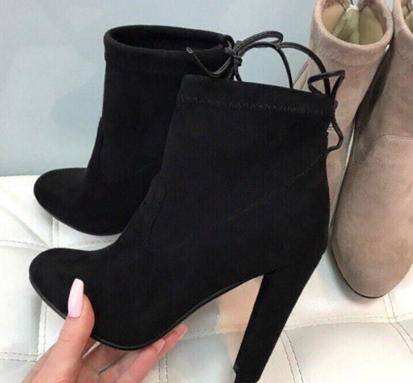 Γυναικείες μπότες με ψηλά τακούνια και ενδιαφέρουσες κορδέλες στο πίσω μέρος του παπουτσιού