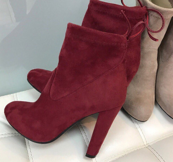 Γυναικείες μπότες με ψηλά τακούνια και ενδιαφέρουσες κορδέλες στο πίσω μέρος του παπουτσιού