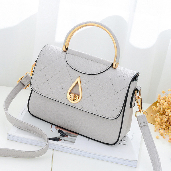 Καθημερινή συμπαγής τσάντα για γυναίκες με μη συνηθισμένη πόρπη και μακρά λαβή