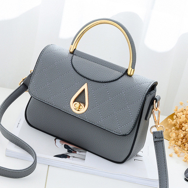 Καθημερινή συμπαγής τσάντα για γυναίκες με μη συνηθισμένη πόρπη και μακρά λαβή