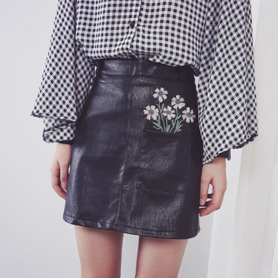 Κομψή φούστα γυναικών σε οικολογικό δέρμα σε μαύρο χρώμα με φυτικά μοτίβα