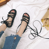 Όμορφη σανδάλια για τις κυρίες με μακριά kozhein δεσμούς σε μαύρο χρώμα