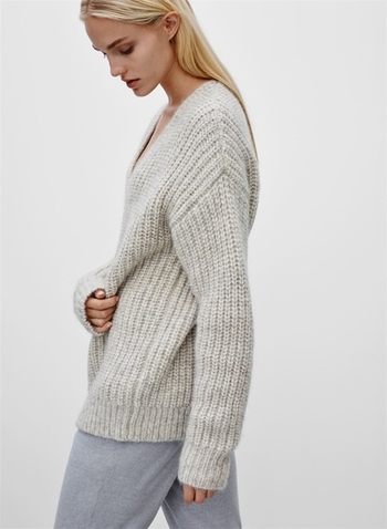 Широк дамски пуловер с плетка и V-образно деколте