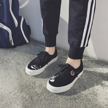 Απλά γυναικεία αθλητικά παπούτσια σε λευκό και μαύρο χρώμα με μια εικόνα