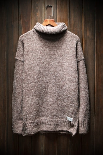 Ένας άνδρας πουλόβερ με ένα χαλαρό μισό γιακά και ένα μακρύ μανίκι